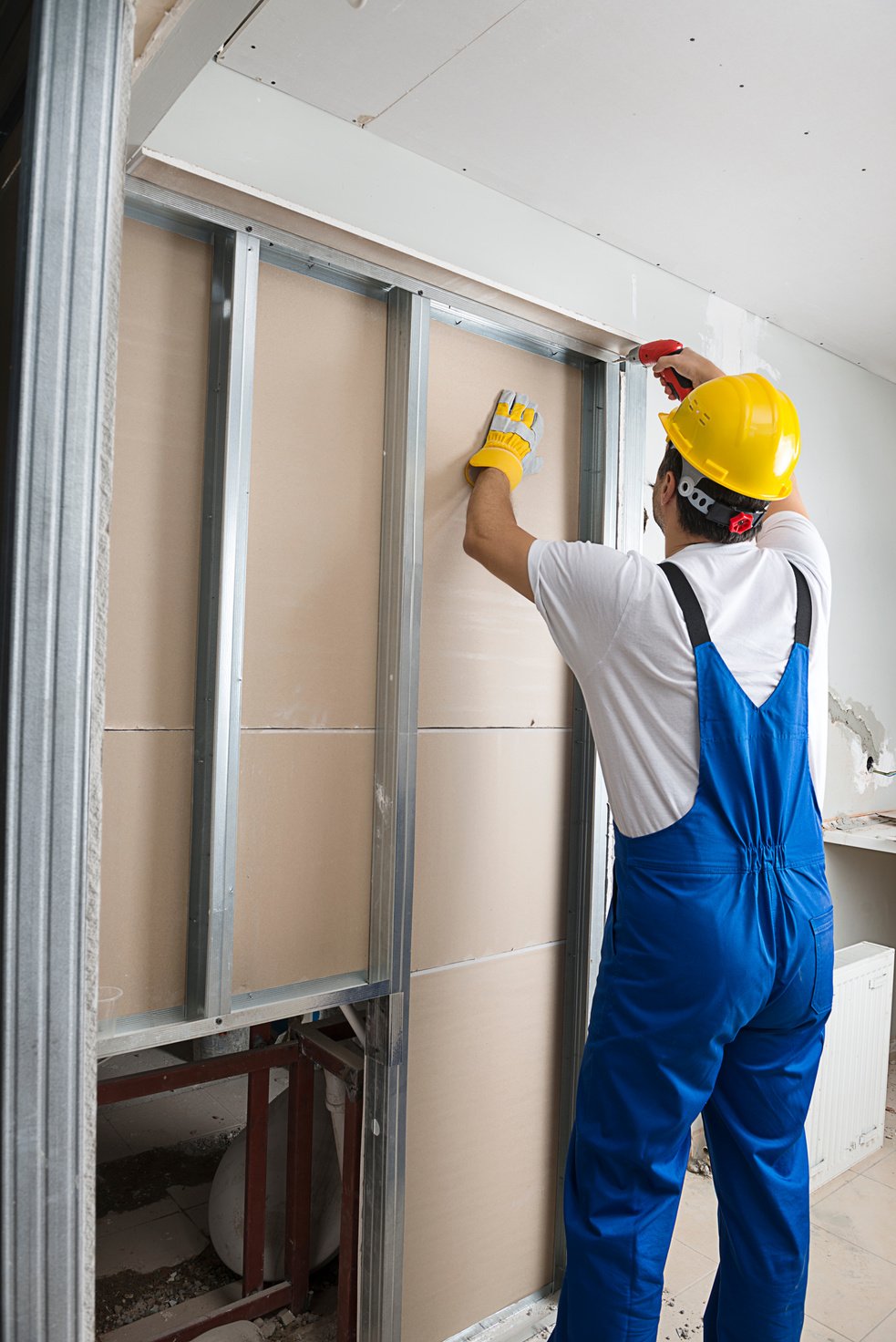 Worker Fixing Drywalls with Cordless Screwdriver